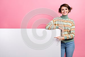 Photo of promoter young lady brown hair point finger huge billboard demonstrate new event invite banner isolated on pink