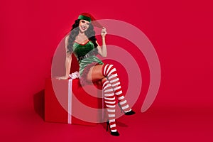 Photo of provocative lady sit present box podium horny foreplay wear hat elf costume isolated red color background photo