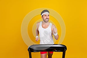 Photo of purposeful funky guy activewear running treadmill looking empty space isolated yellow color background