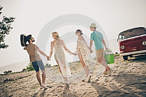 Photo of relaxed friends hold hands prepare chill road youth journey wear casual outfit nature seaside beach outdoors