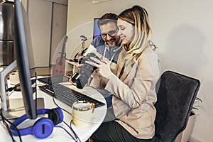 Two young photographers working in office