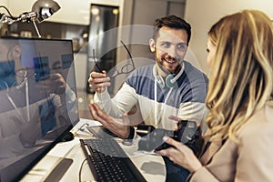 Two young photographers working in office