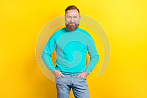 Photo of retired confident man wear teal clothes hand in pockets finished work task isolated on yellow color background
