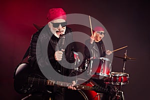 Photo of retired lady man popular old rock group family play solo guitar drum sticks sing legend famous song concert