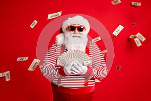 Photo of retired old grandpa hold cash fan prepare spend money newyear charity wear santa costume suspenders sunglass
