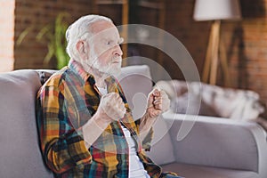 Photo of retired old man granddad grey hair raise fists watch bad news politics angry wear casual checkered look sitting