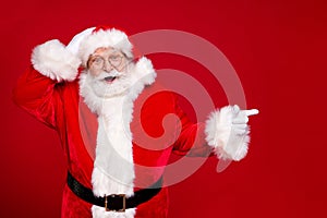 Photo of retired old man grey beard hand head direct finger empty space suggest mad novelty wear santa x-mas costume