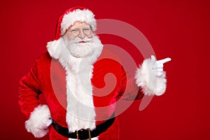 Photo of retired old man grey beard hand hip direct finger empty space propose newyear decor wear santa costume leather