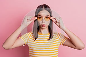 Photo of romantic coquette dream lady fingers hold sunglass lips send air kiss on pink background