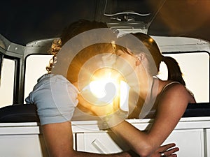 Romantic young couple kissing in campervan
