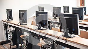Photo of row computers in classroom or other educational institution