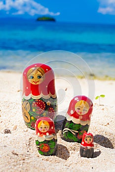 Photo Rows Puzzle Russian Dolls Matrioshka Family Souvenir Untouched Tropical Beach in Bali Island. Vertical Picture