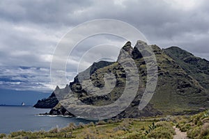 Photo of a rugged mountain jutting into the sea photo