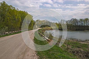 photo of rural road with lake.