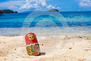 Photo Russian Handmade Dolls Matrioshka Untouched Tropical Beach in Bali Island. Horizontal Picture. Blurred Background