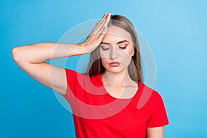 Photo of sad disappointed girl closed eyes wearing red clothes touching head suffering pain isolated on blue color