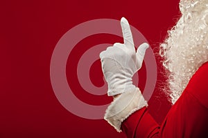 Photo of Santa Claus gloved hand in pointing gesture. fingers