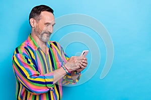 Photo of satisfied brunet hair mature age man wear striped colorful shirt hold his apple iphone choose eshop gift