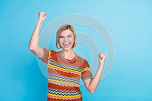 Photo of satisfied crazy woman with bob hairdo dressed knitwear t-shirt win bet scream clenching fists isolated on blue
