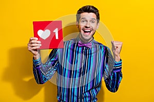 Photo of satisfied ecstatic funny man with stubble dressed striped shirt get one more like on post isolated on yellow