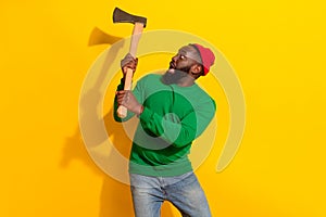 Photo of scared lumberjack man hold sharp axe scared face wear red beanie green pullover isolated yellow color