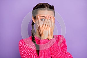Photo of scared shocked young woman hold hands cover face peek eye isolated on purple color background