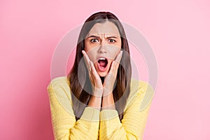 Photo of scared terrified young woman dressed casual clothes open mouth arms cheeks  pastel pink color