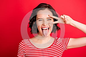 Photo of screaming girl showing her tongue after having eaten hot sauce while isolated with red background