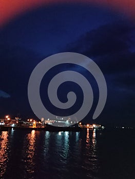 Photo of a seascape at night, with house lights on