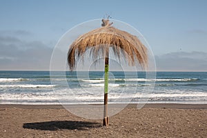  beach in the pacific ocean on  sunny day and  rustic  umbrella in the middle of photo