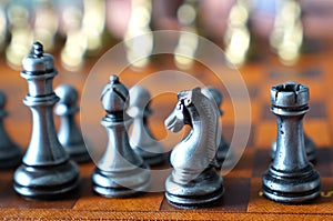 Photo in selective focus of a chess board and metal chess pieces