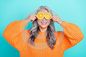 Photo of senior lovely woman have fun cover eyes citrus good mood hiding playful isolated over teal color background