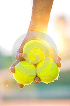 Photo of senior man holding tennis balls on court