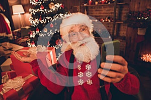 Photo of senior santa claus happy positive smile speak video call smartphone show decoration christmas time indoors
