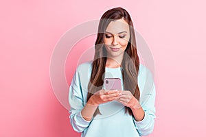 Photo of serious brown haired young woman hold smartphone texting media isolated on shine pink color background