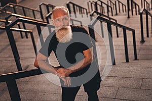 Photo of serious concentrated pensioner coach man stand strong stairs wear t-shirt urban town outdoors