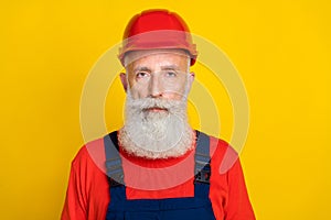 Photo of serious confident age man workwear uniform red hard hat isolated yellow color background