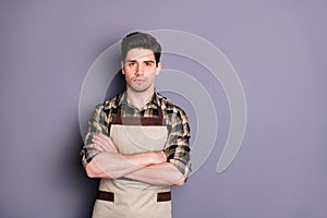 Photo of serious confident barista with arms crossed looking pensively at you near empty space  grey color