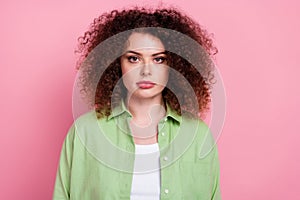 Photo of serious confident pleasant woman with perming coiffure dressed green shirt look at camera isolated on pink