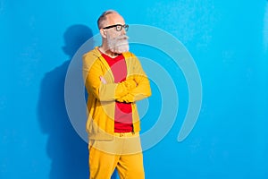 Photo of serious focused thoughtful mature man in glasses look copyspace thinking crossed arms isolated on blue color