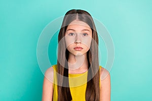 Photo of serious nice brown hair girl wear yellow dress isolated on bright teal color background