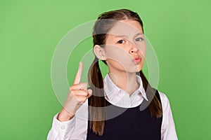 Photo of serious strict school girl dressed formal clothes pointing finger  green color background