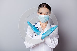 Photo of serious virologist doc lady experienced professional hold crossed palms infected zone wear gloves facial mask