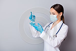 Photo of serious virologist doc lady experienced professional hold glass test flask tube examining vaccine wear gloves