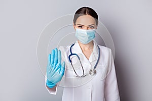 Photo of serious virologist doc lady professional hold palm stop patients stepping infected zone wear gloves facial mask