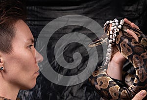 Photo of serious woman looking into snakes eyes