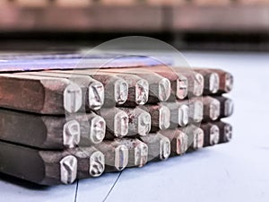 Photo a set of alphabetical steel punches in blue plastic box.