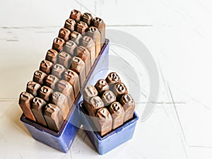 Photo a set of numirecal and alphabetical steel punches in blue plastic box.