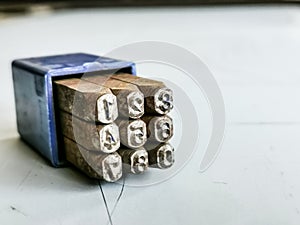 Photo a set of numirecal steel punches in blue plastic box.