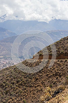 Photo of several mountains and the road to Pavas at noon, diverse vegetation and a shining sun. Located in Caraz